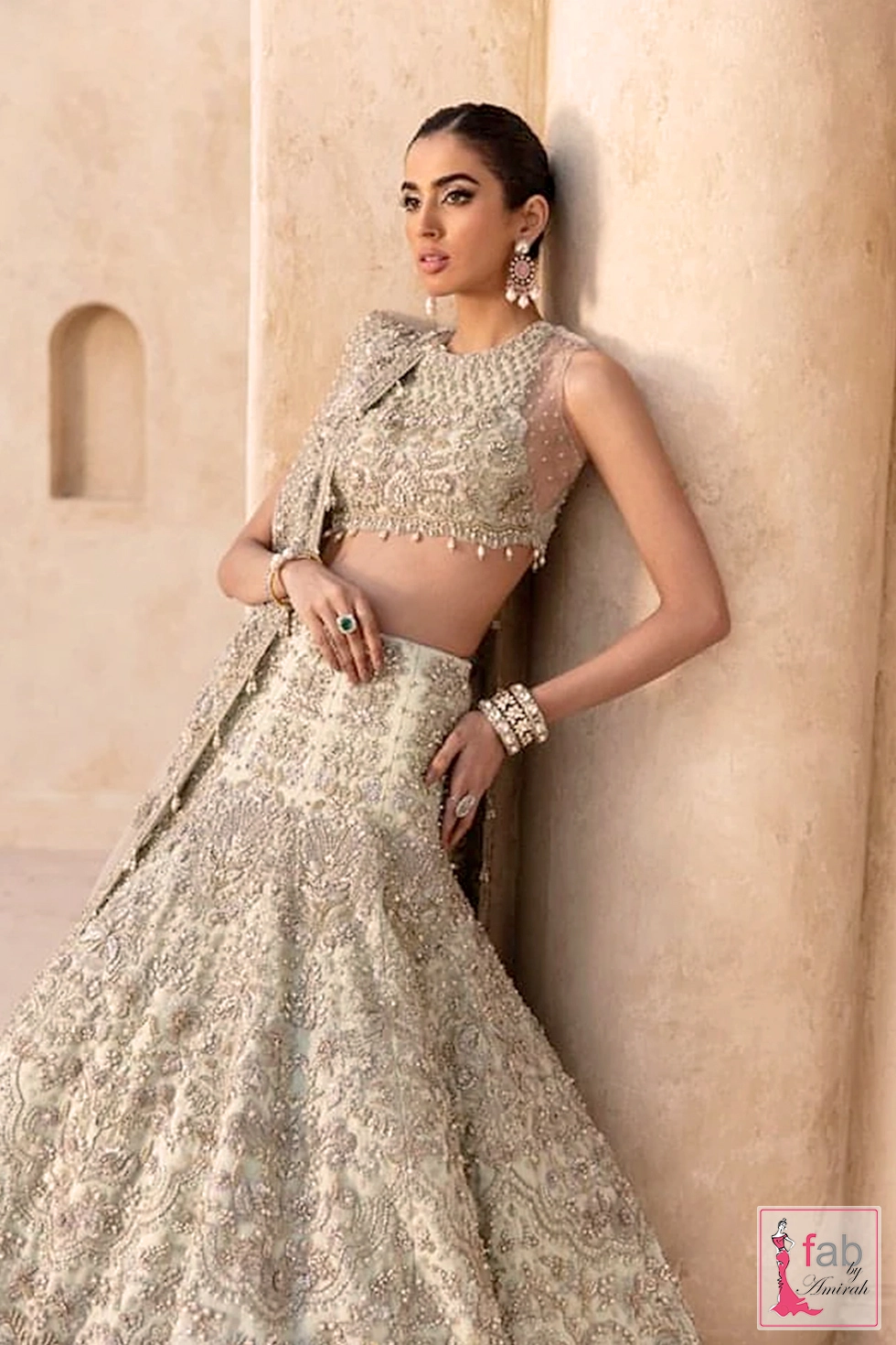 Three quarter shot showing sheer back design and embellishments of mint green lehenga