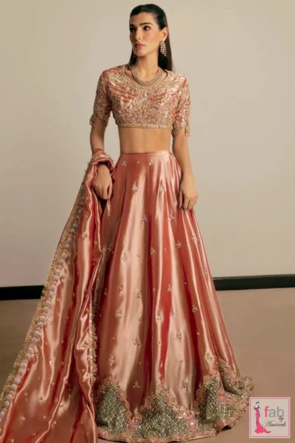 Full front view of dusty pink tissue lehenga choli showing flared skirt and choli blouse