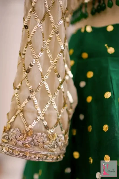 Detail shot of full length sheer sleeve with sequin grid pattern and floral cuff embroidery