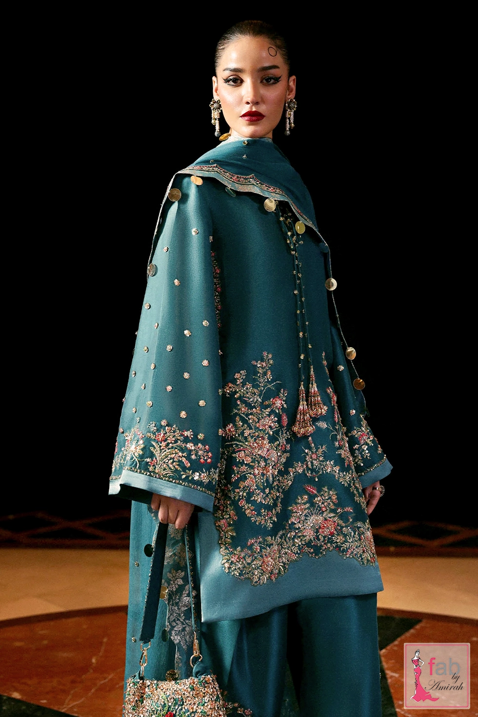 Three quarter view of teal blue hand embroidered tunic and matching trousers