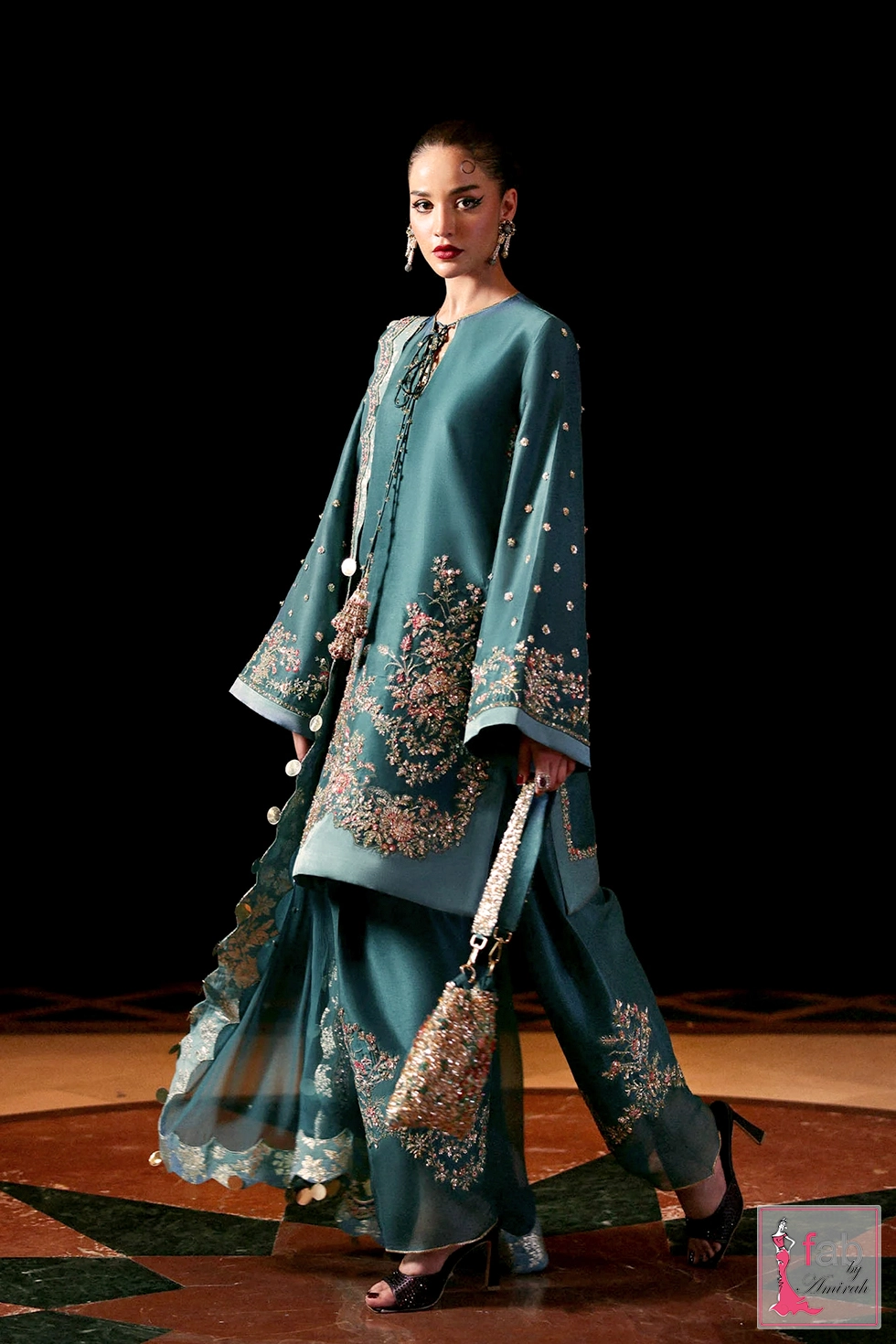 Full length side pose showing fluid silhouette of teal blue outfit