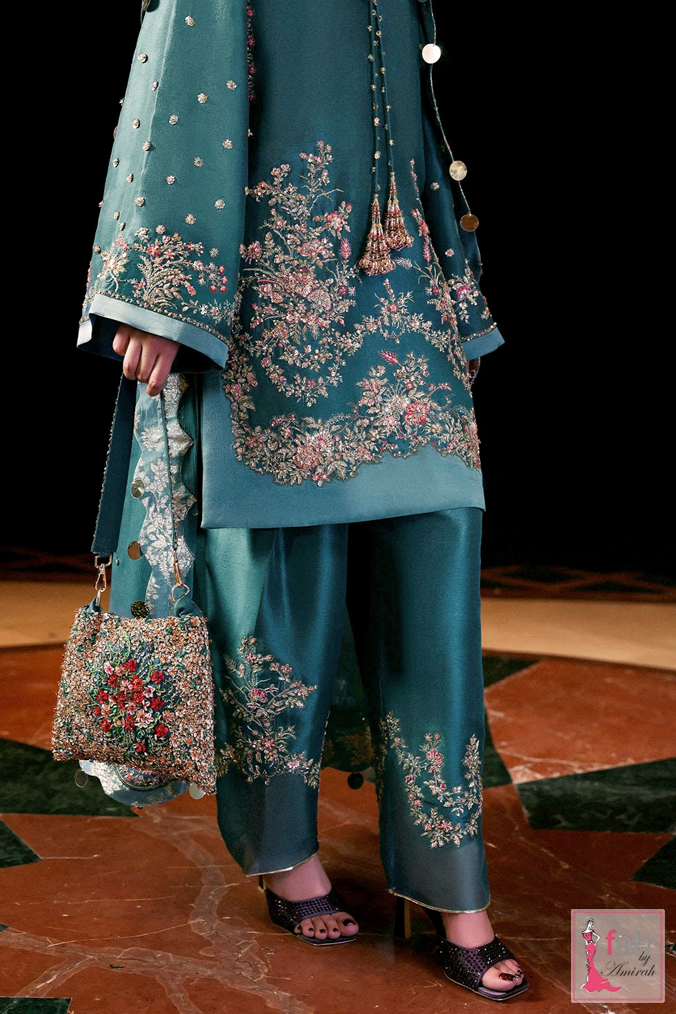 Detailed shot of embroidered trousers hem and matching embellishment pouch