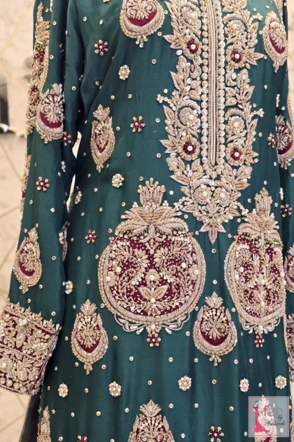 Detailed shot of heavily hand embellished motif patterns on dark green bodice