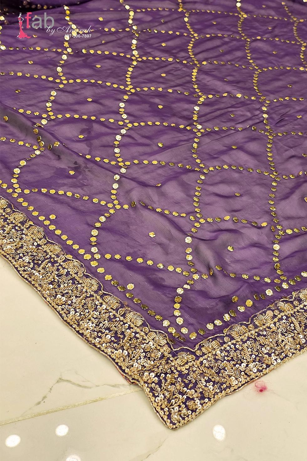 Close up of sheer purple dupatta featuring gold sequin grid pattern