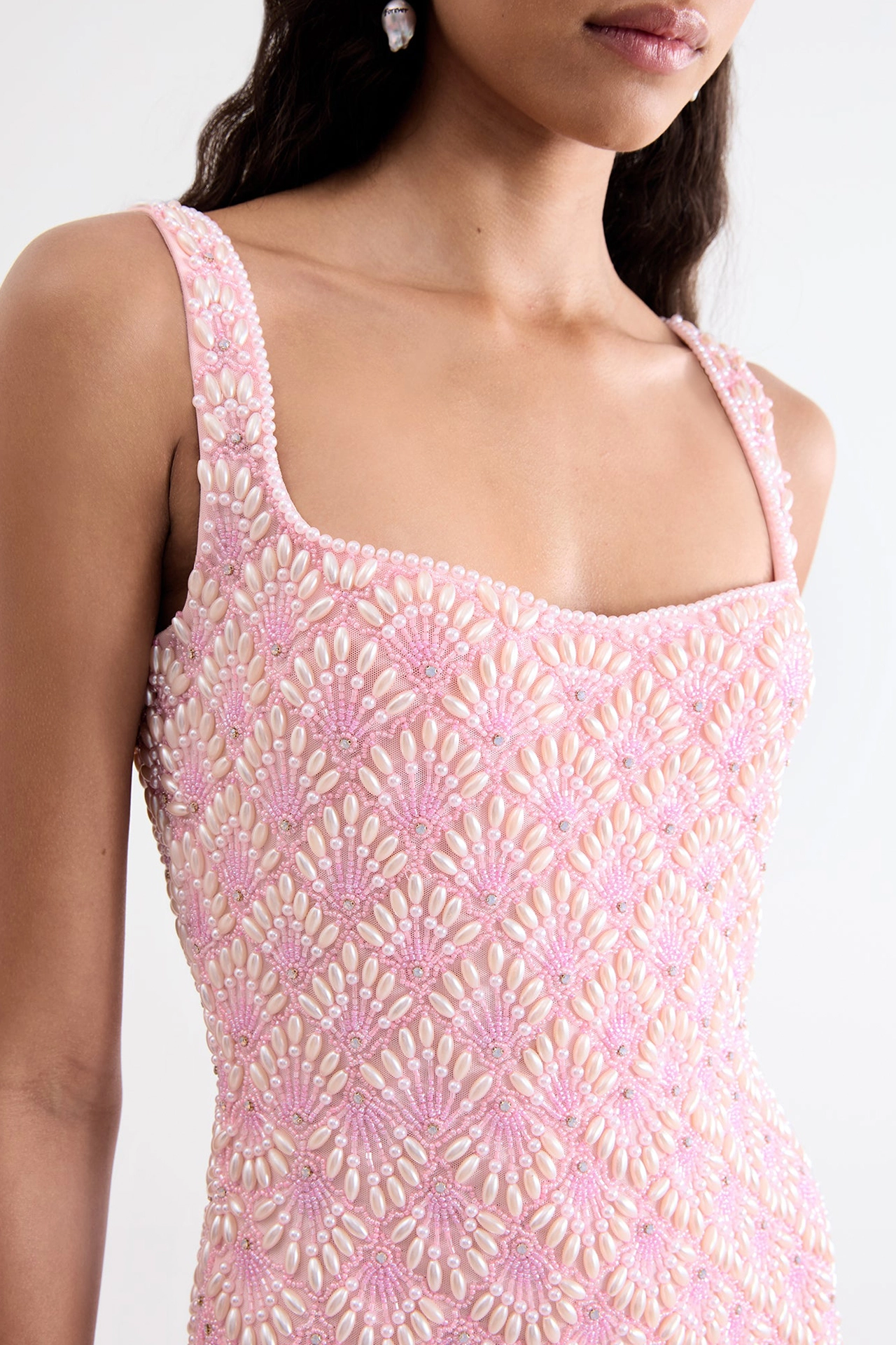 Close-up of model wearing rose pink mini dress showing elegant square neck structure