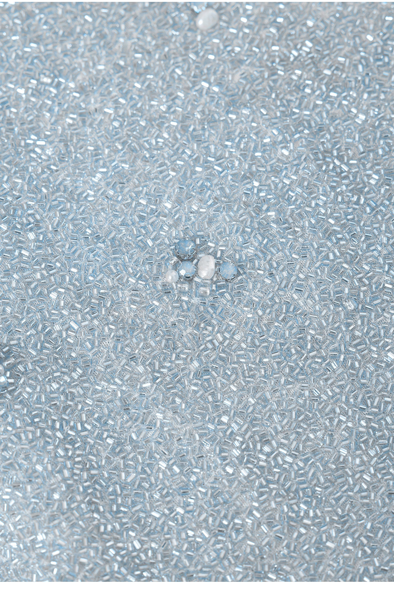 Close-up of sparkling blue mini dress fabric showing glass shimmer beads and pearl accents