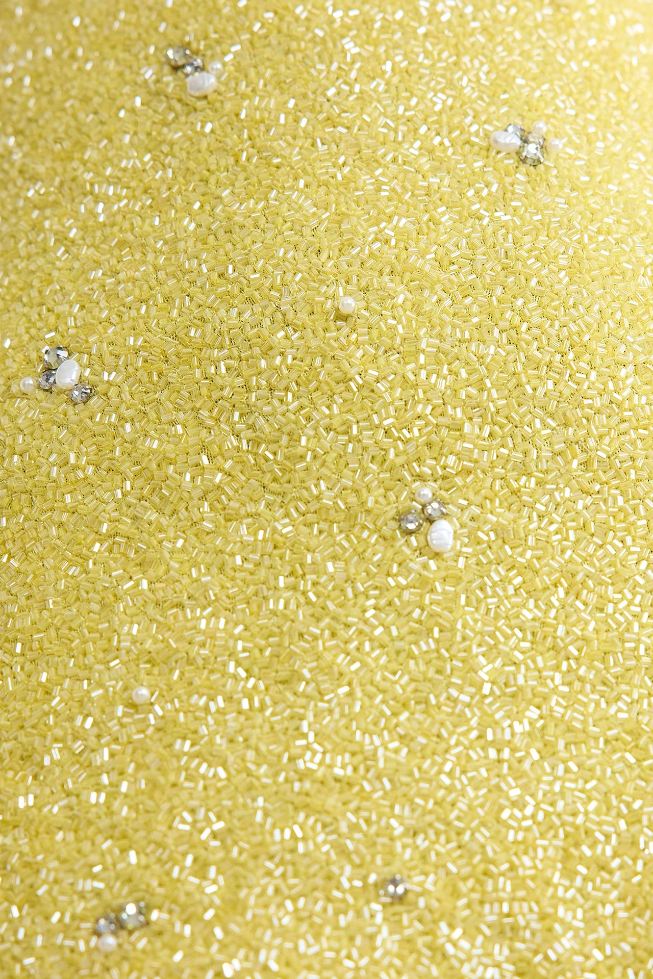 Close-up of yellow dress with crystals showing micro glass beads and pearl clusters