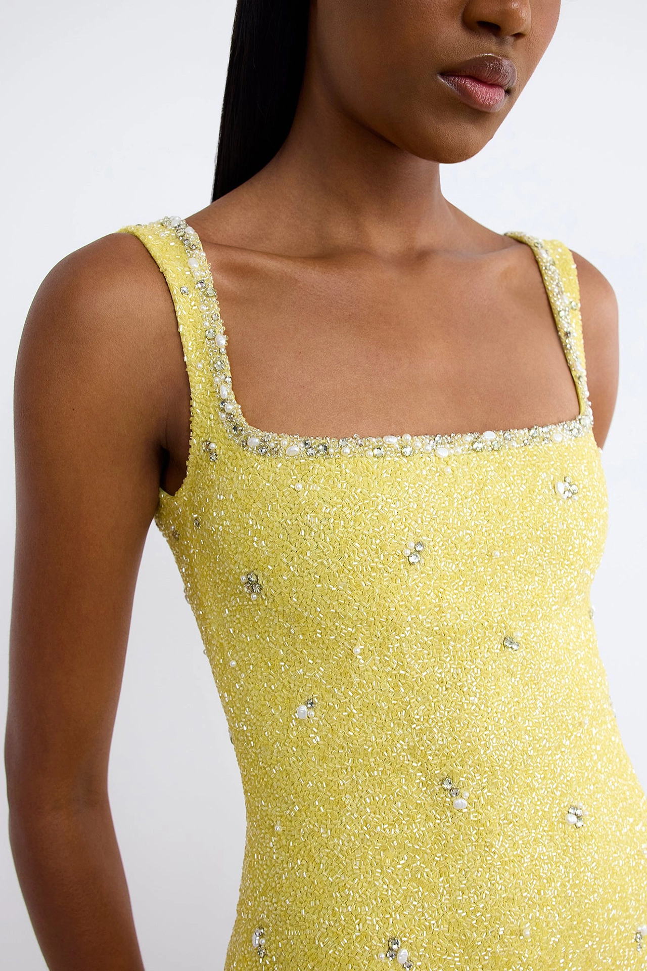 Model from back showing low scoop back style of yellow dress with crystals