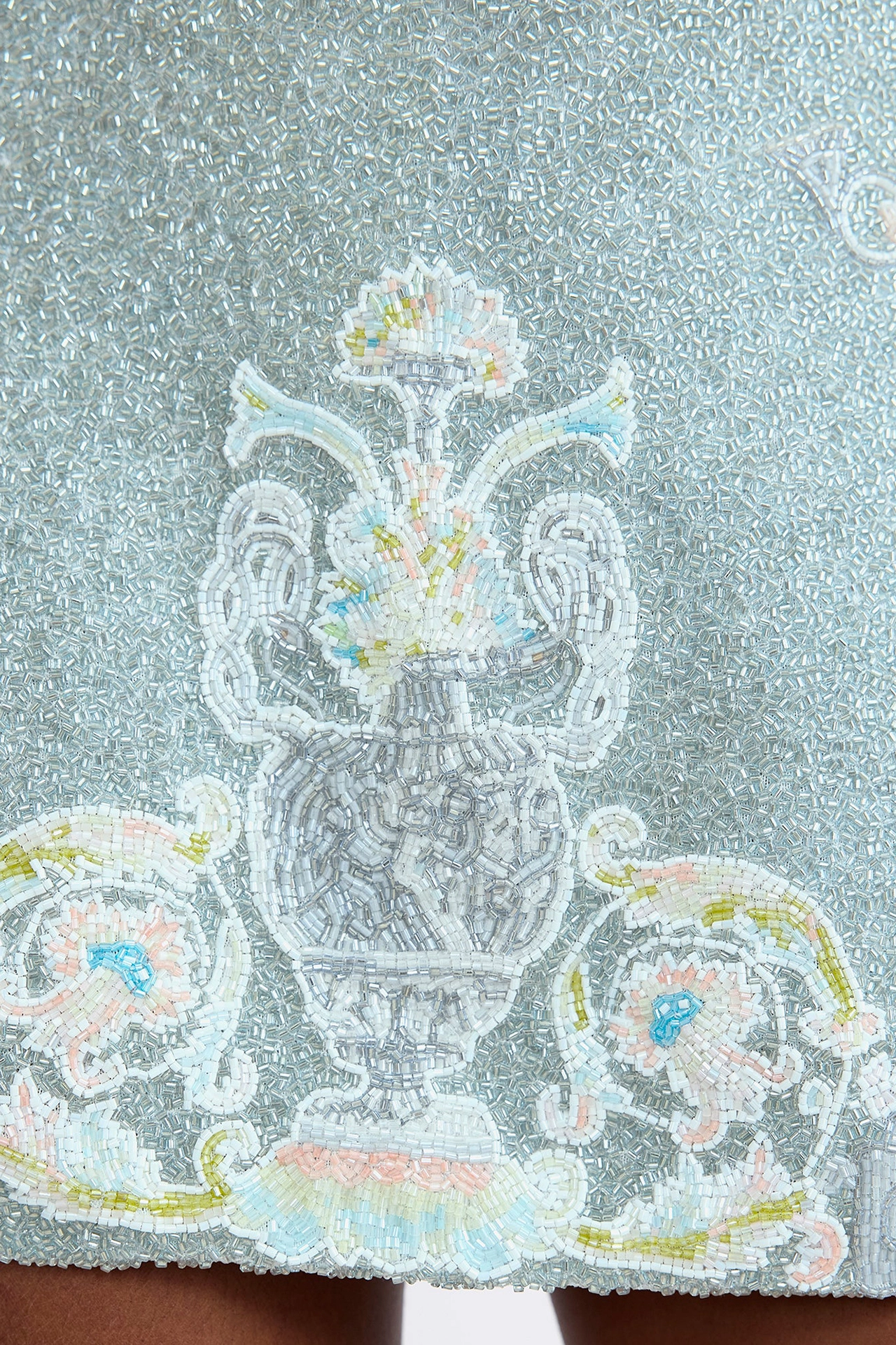Close-up of gold and silver hand-embellished renaissance motifs on luxury beaded party mini dress
