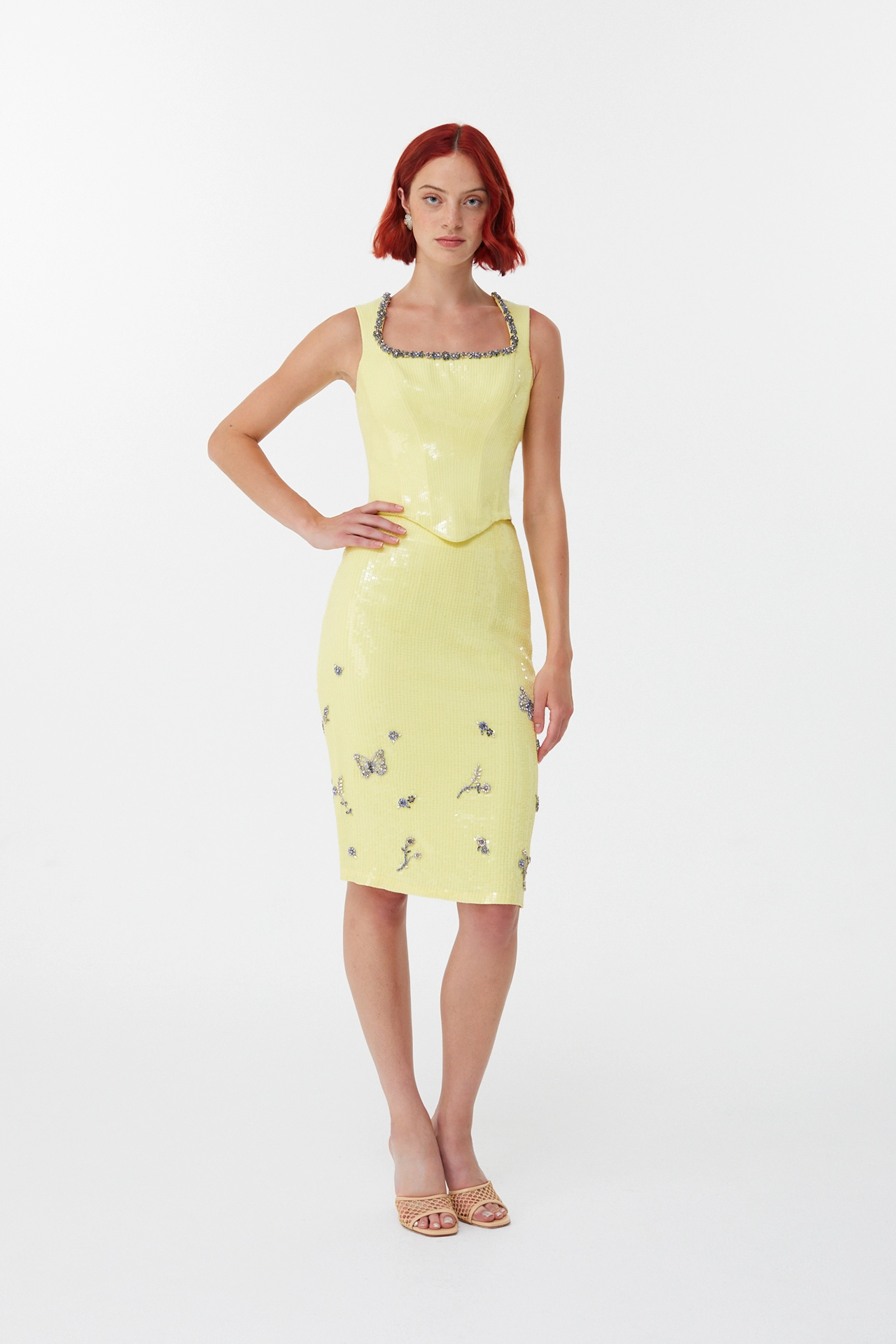 Full length look of shiny yellow party skirt styled with beige woven heels