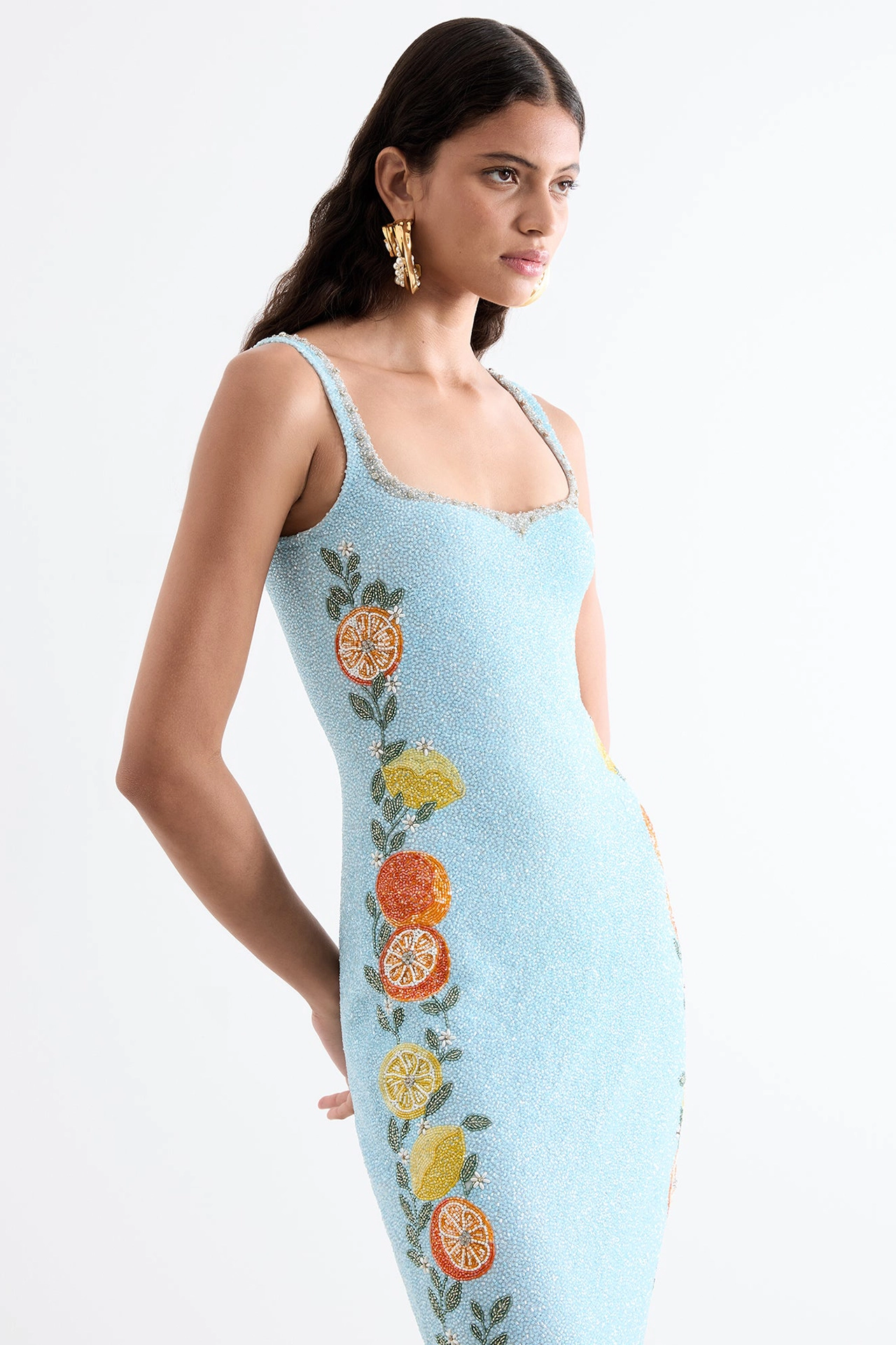 Full length model shot of light blue beaded maxi dress with gold earrings from Capri Gown