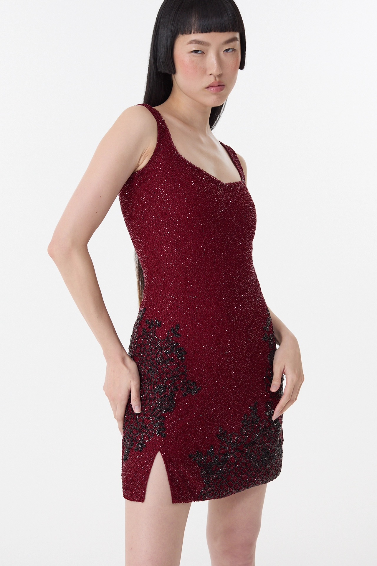 Model wearing garnet red short dress with black strap heels