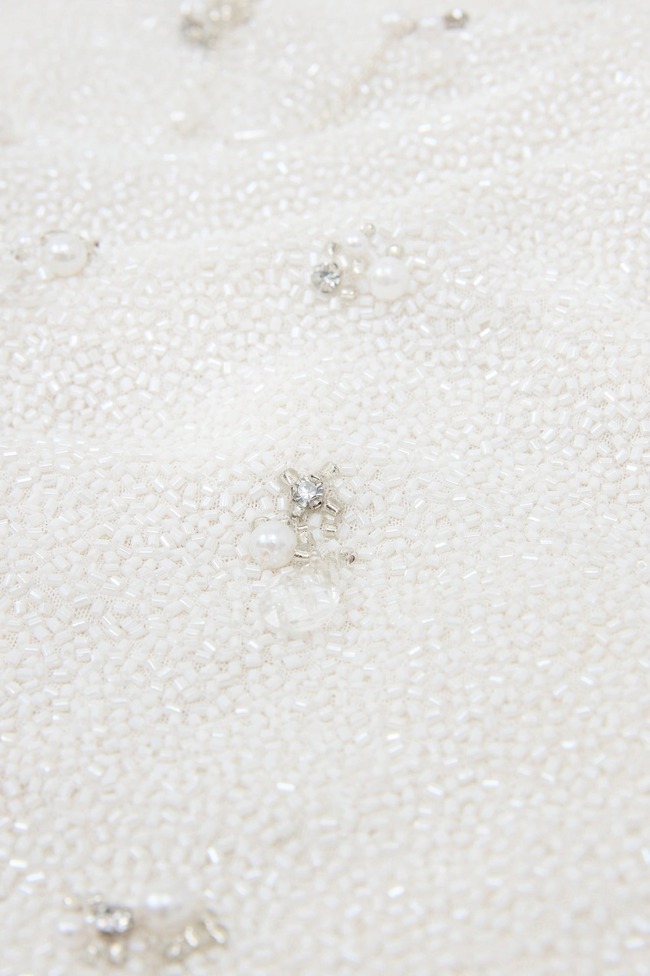 Extreme close-up of hand-sewn silver crystals and glass beads from Droplet Mini Mannequin