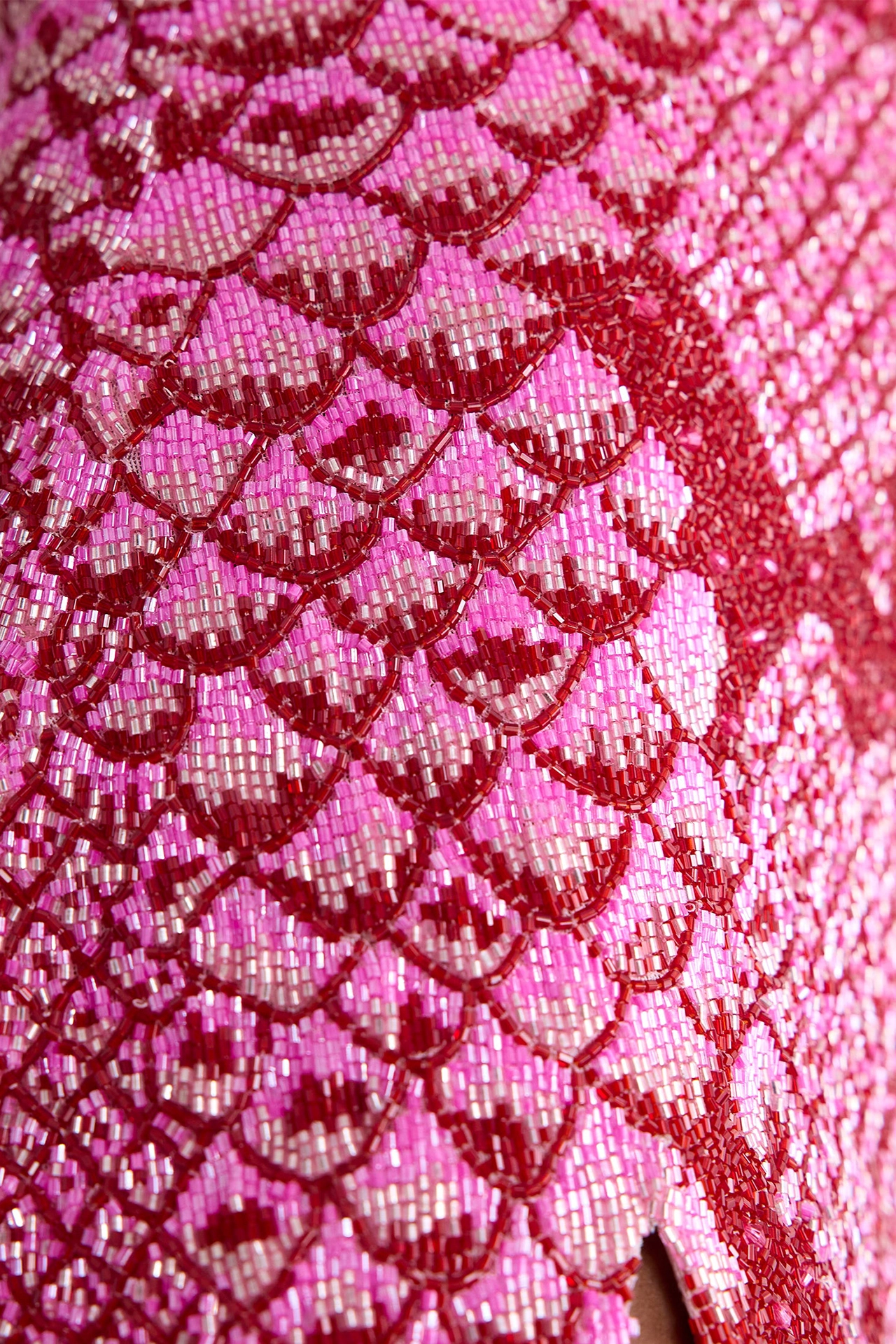 Close-up of hot pink cocktail dress showing shimmering snakeskin-inspired beadwork details