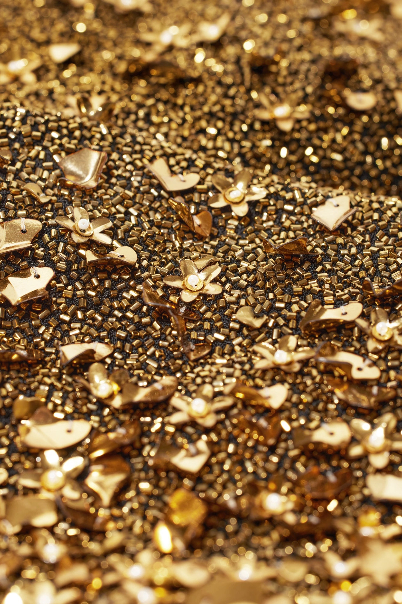 Close-up of cascading gold sequin party dress metallic beads and flower detail