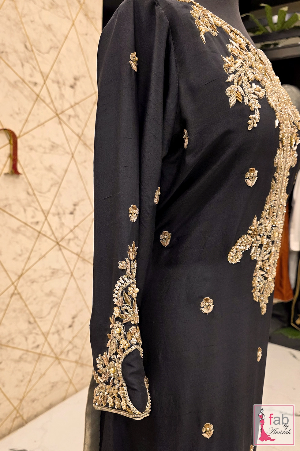 Close-up of champagne tilla and micro-pearl embroidery on jet black raw silk tunic Close-up of champagne tilla and micro-pearl embroidery on jet black raw silk tunic
