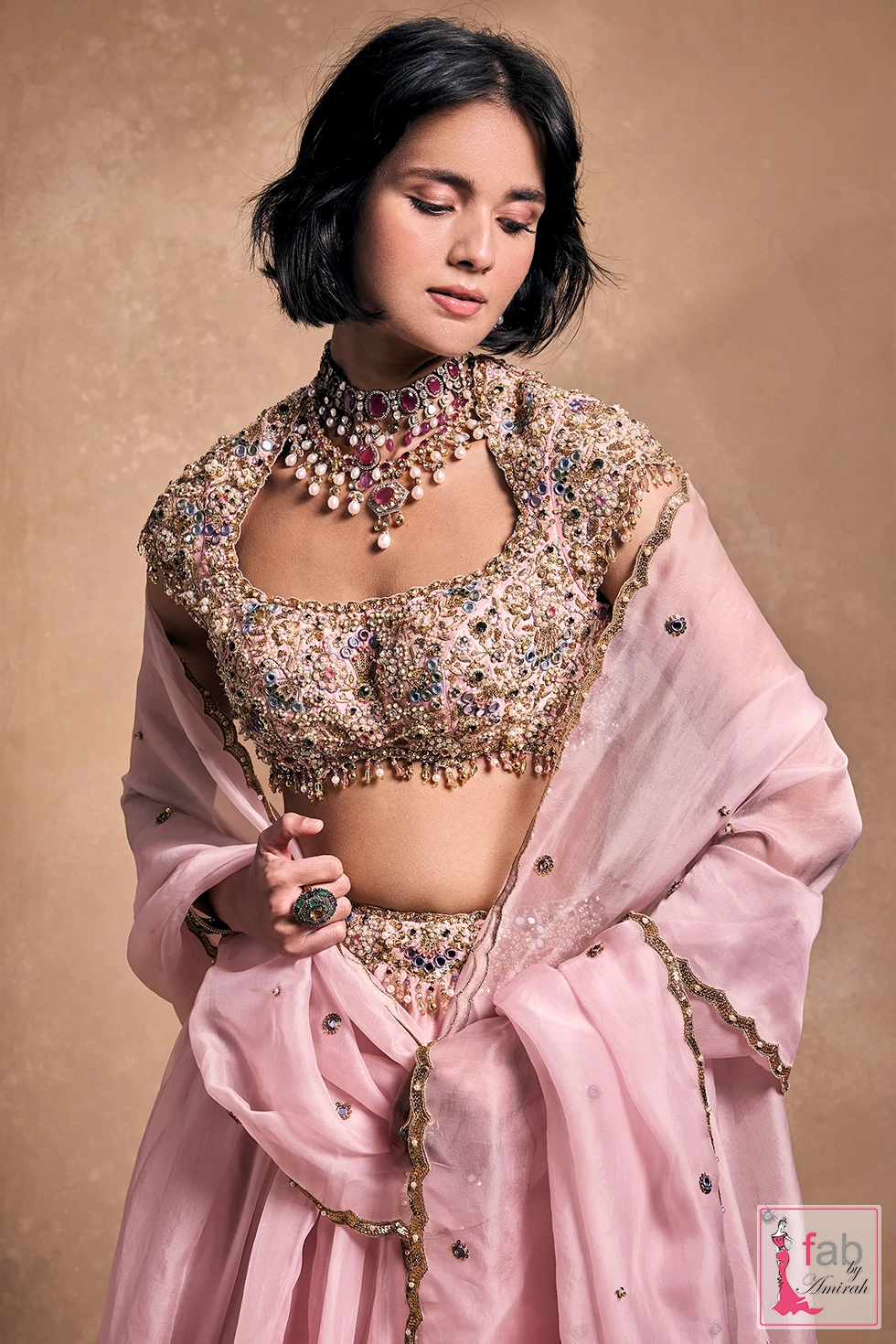 Detailed shot of intricate blouse embellishments and pink organza drape Detailed shot of intricate blouse embellishments and pink organza drape