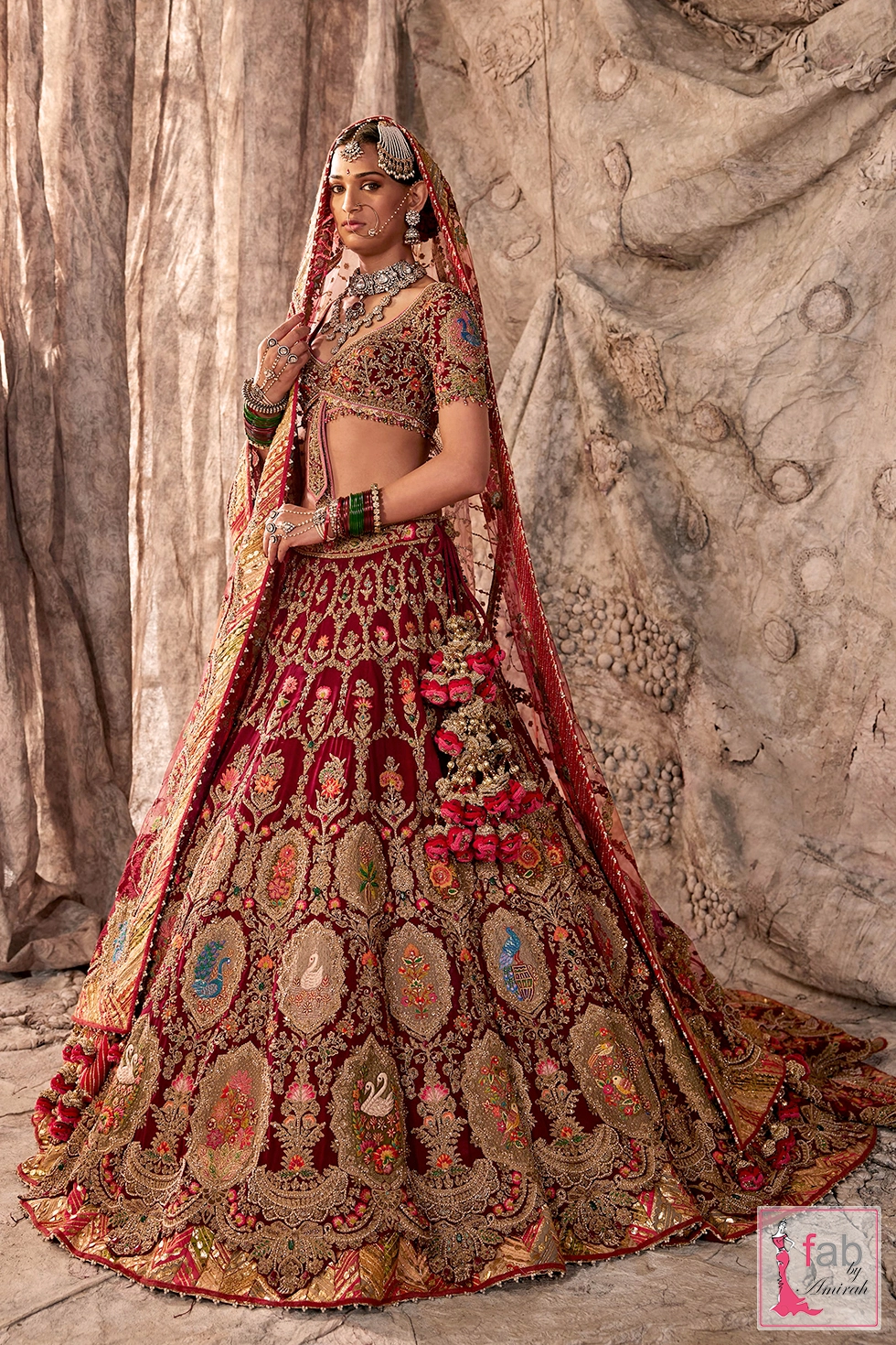 Red bridal lehenga choli featuring gold embroidery and a diaphanous tulle dupatta.