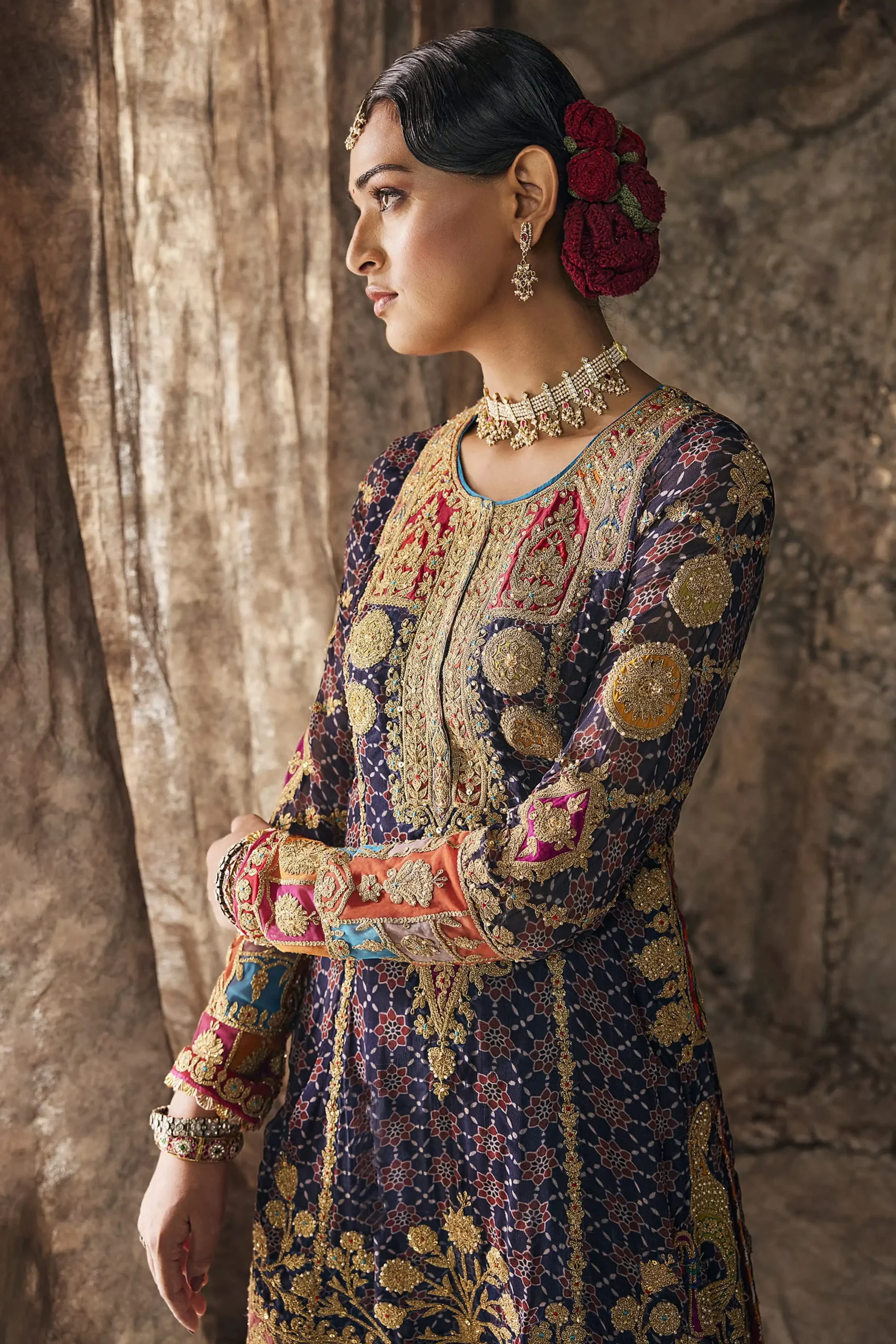 Mid length shot of designer party wear dress focusing on intricate gold chest panel embroidery and jewel encrusted choker. Mid length shot of designer party wear dress focusing on intricate gold chest panel embroidery and jewel encrusted choker.