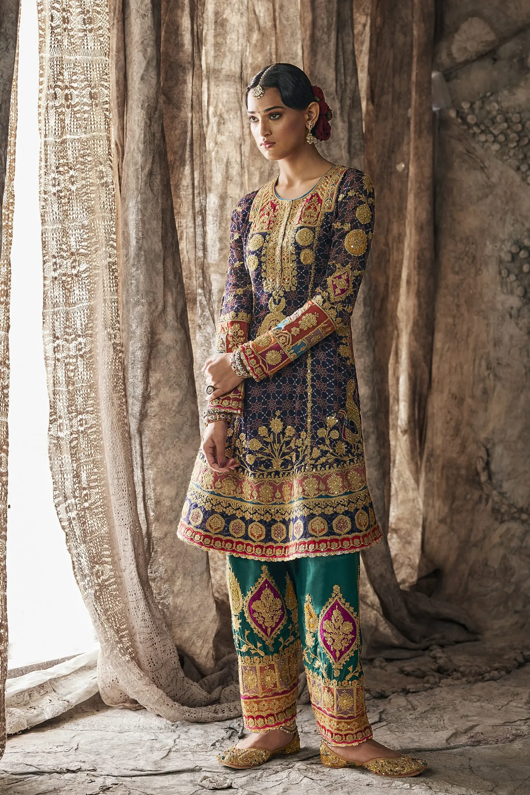 Full standing portrait of designer party wear dress highlighting gold zardozi hemline and multi colored sleeve cuffs. Full standing portrait of designer party wear dress highlighting gold zardozi hemline and multi colored sleeve cuffs.