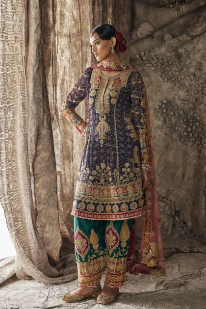 Full length front view of dark navy designer party wear dress paired with emerald green embroidered salwar.
