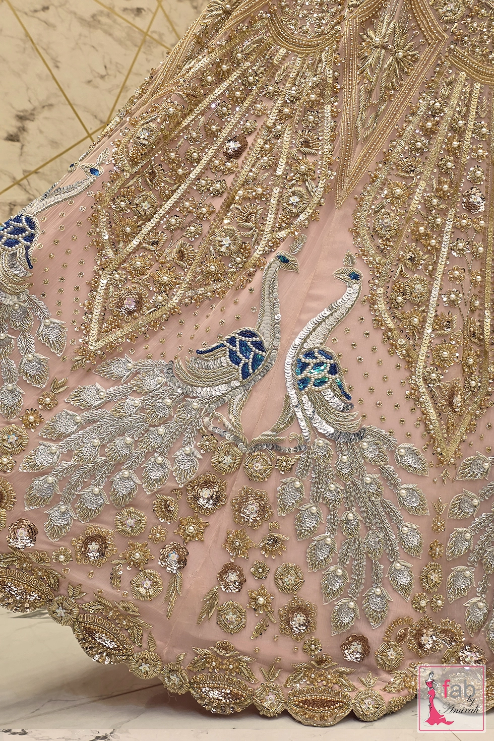 Detail shot of silver peacock motifs adorned with blue sequins Detail shot of silver peacock motifs adorned with blue sequins