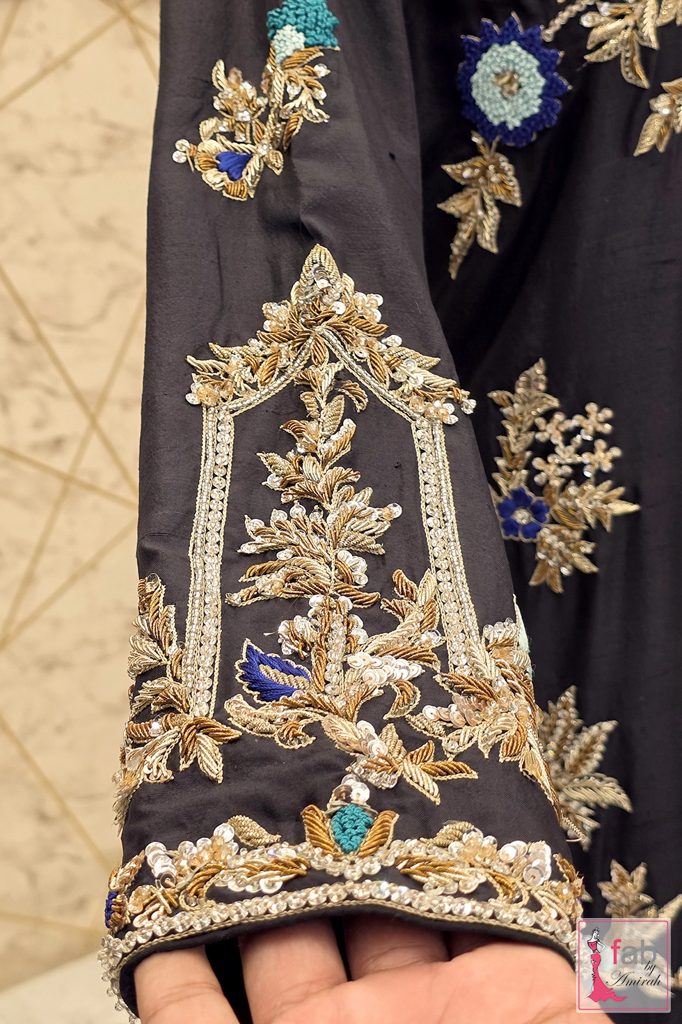 Close up detail of sleeve cuff with gold tilla and blue bead embroidery Close up detail of sleeve cuff with gold tilla and blue bead embroidery