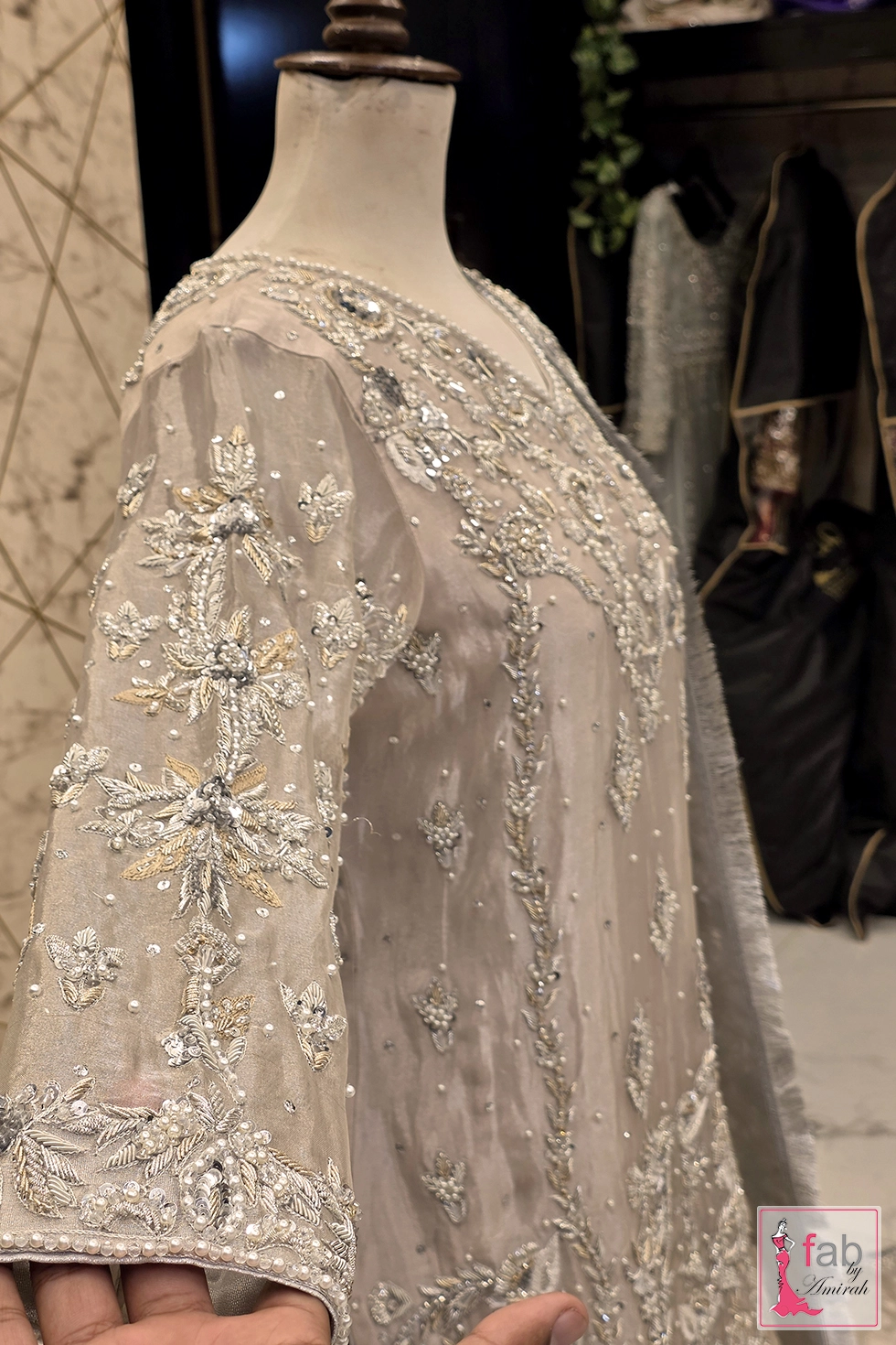 Close up view of hand embroidered sleeves with floral zardozi and pearl details