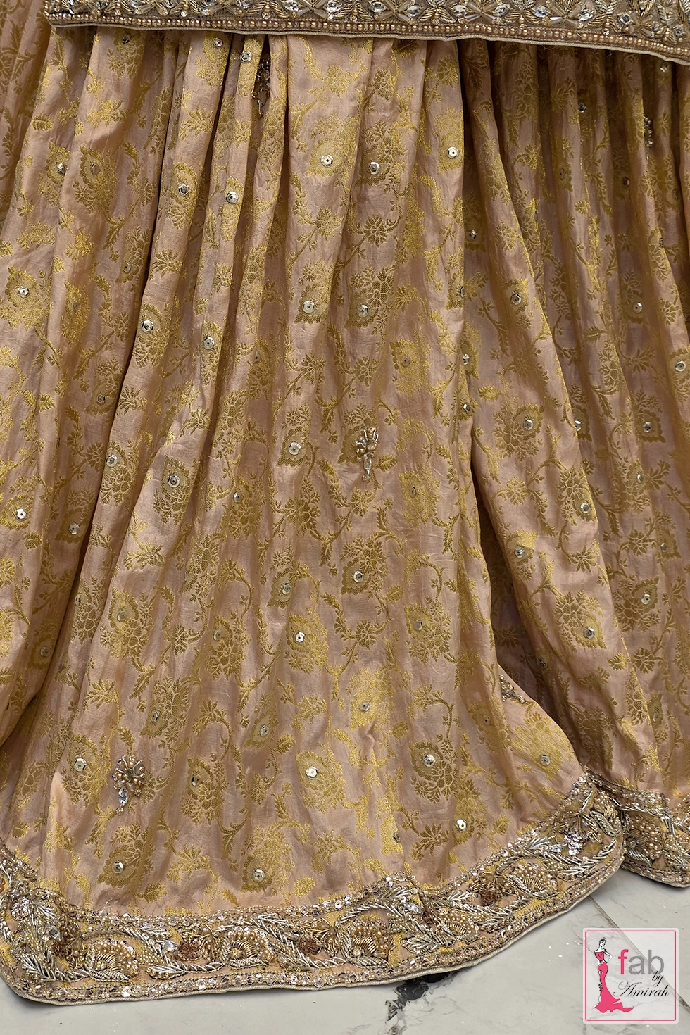 Close up shot of the muted gold brocade fabric texture with subtle shimmer and intricate bottom border detailing