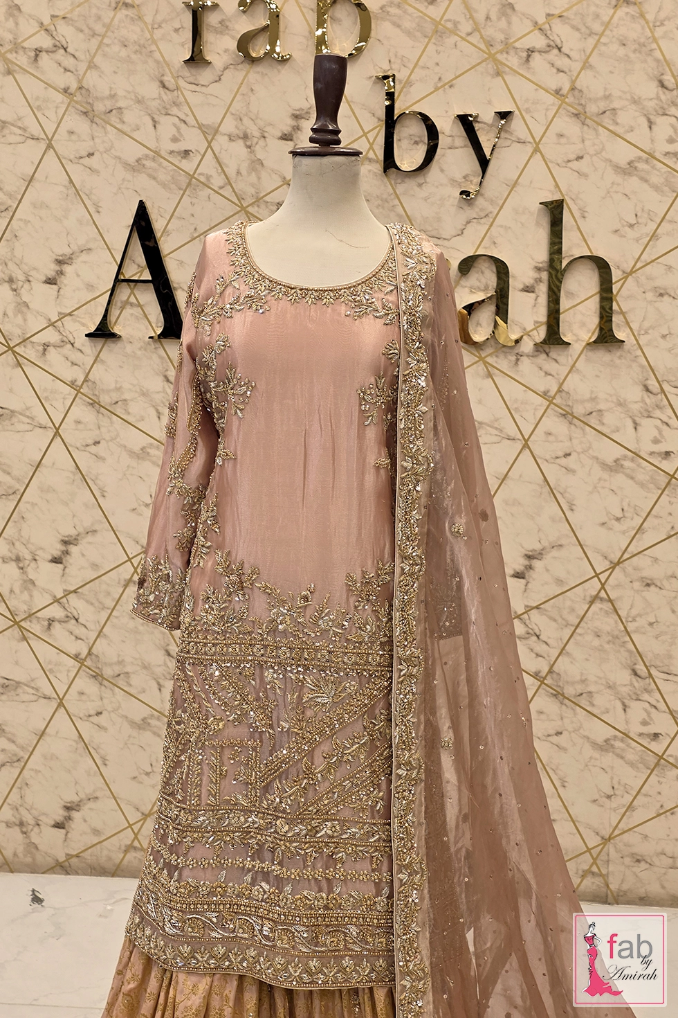 Mid shot view displaying the upper body fit, neckline embellishment, and upper skirt flare on marble backdrop