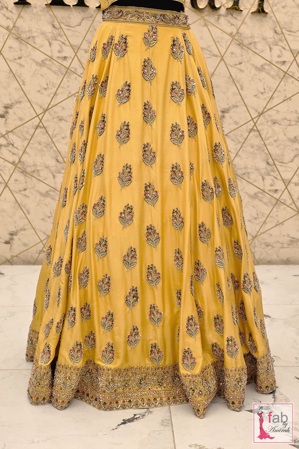 Detailed view of floral booti motifs on yellow lehenga skirt flare