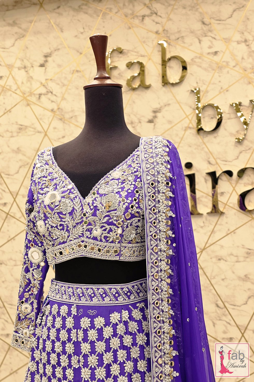 Close up of purple choli showing V neckline and sleeve mirror work Close up of purple choli showing V neckline and sleeve mirror work