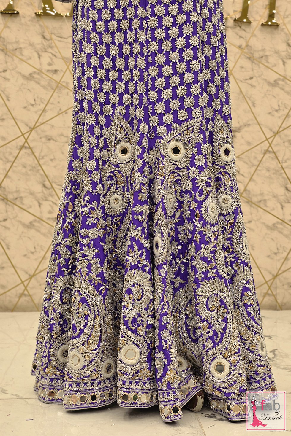 Detail of paisley motifs and mirror work on purple skirt hem Detail of paisley motifs and mirror work on purple skirt hem