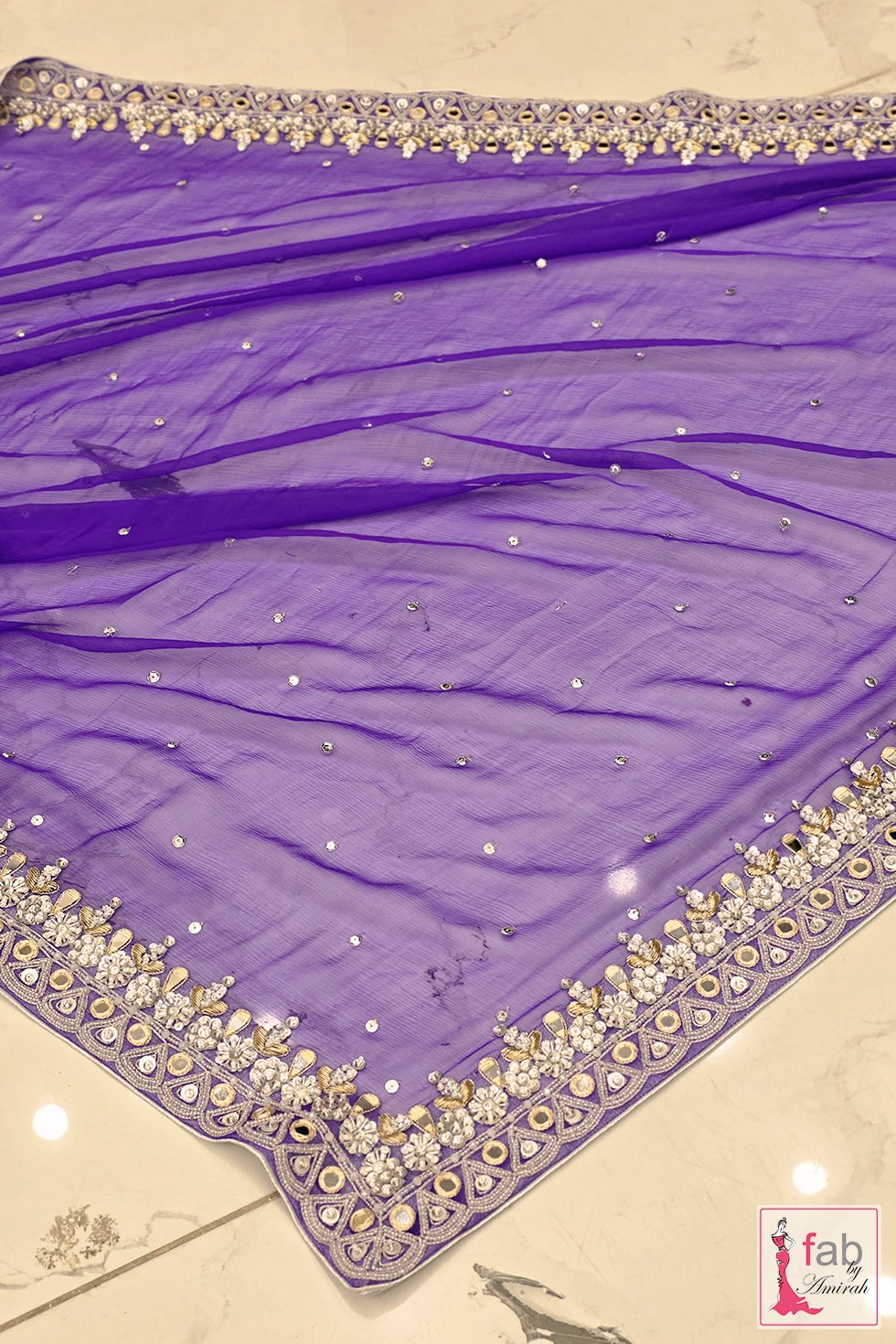 Sheer purple net dupatta with embellished borders laying flat Sheer purple net dupatta with embellished borders laying flat