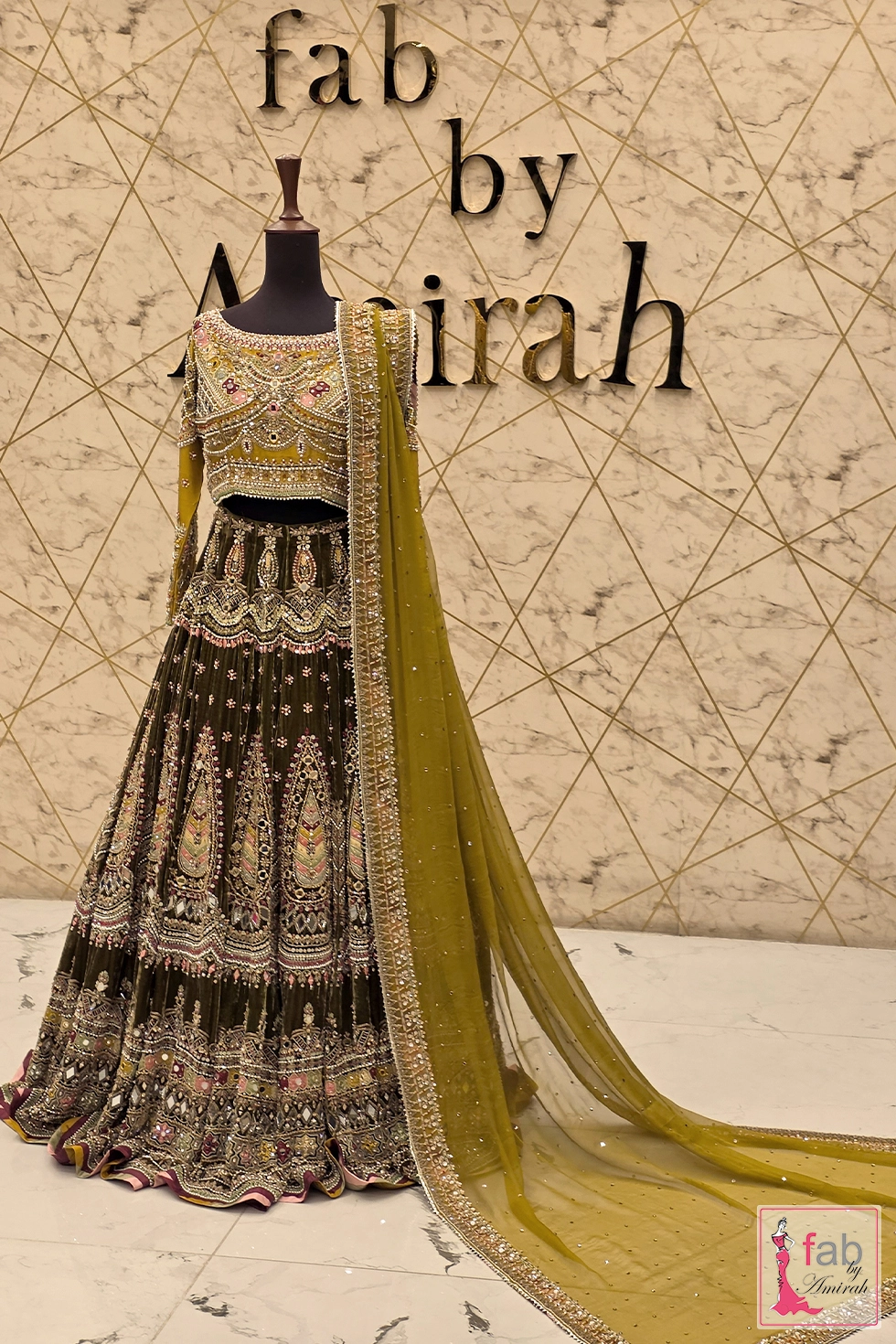 Olive green velvet lehenga displayed on full mannequin with dupatta draped