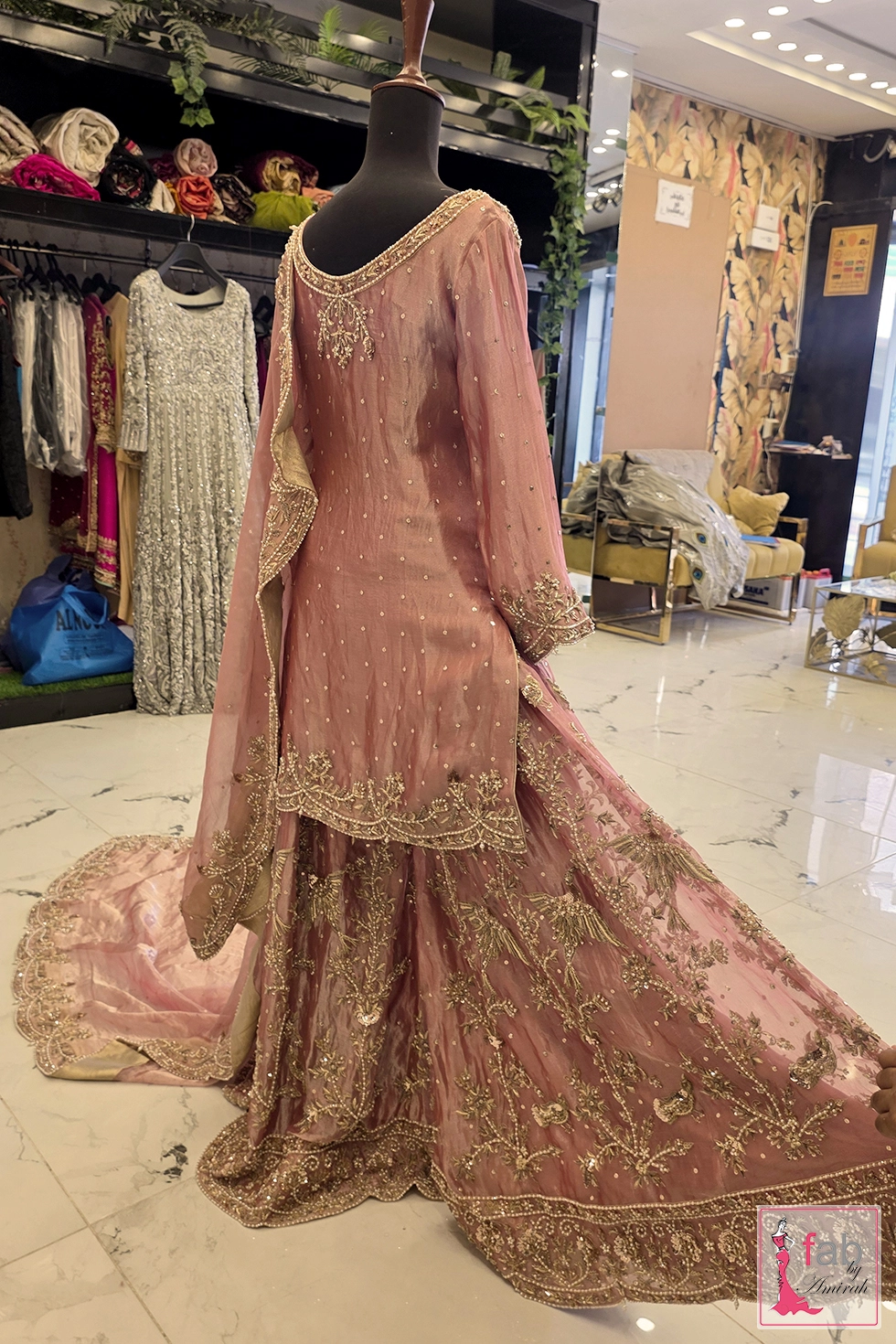 Back view of dusty pink sharara suit with embroidered dupatta on display mannequin.