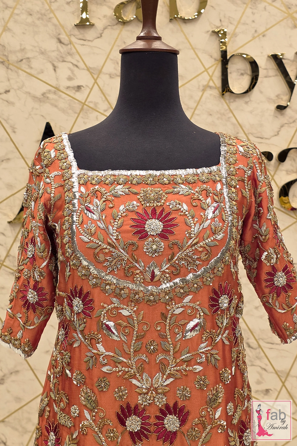 Close up of side slit embroidery detail on rust silk shirt Close up of side slit embroidery detail on rust silk shirt