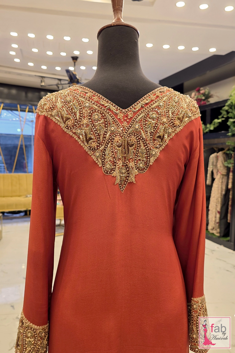 Back view of ornate neck embroidery pattern on terracotta outfit