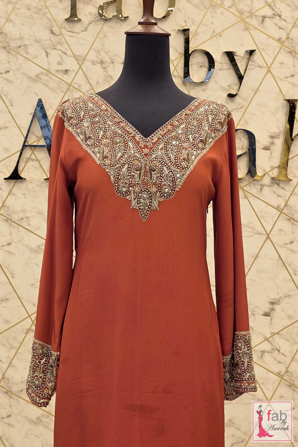 Close up of V neckline embroidery on rust party wear dress