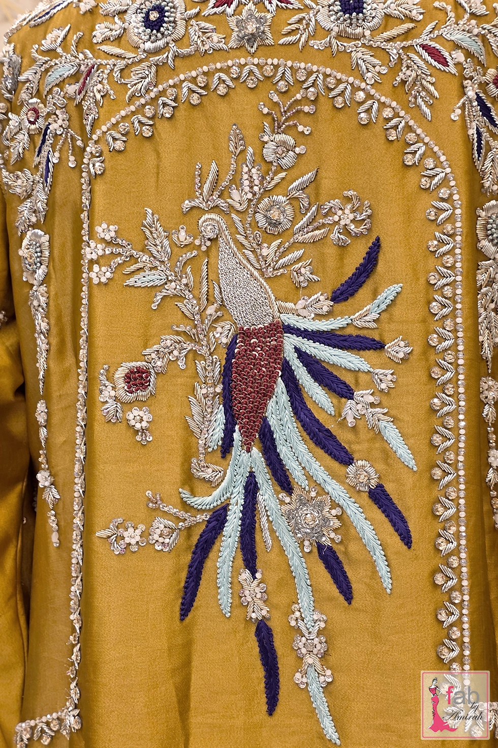 Detailed view of hand embroidered peacock motif on tunic back Detailed view of hand embroidered peacock motif on tunic back