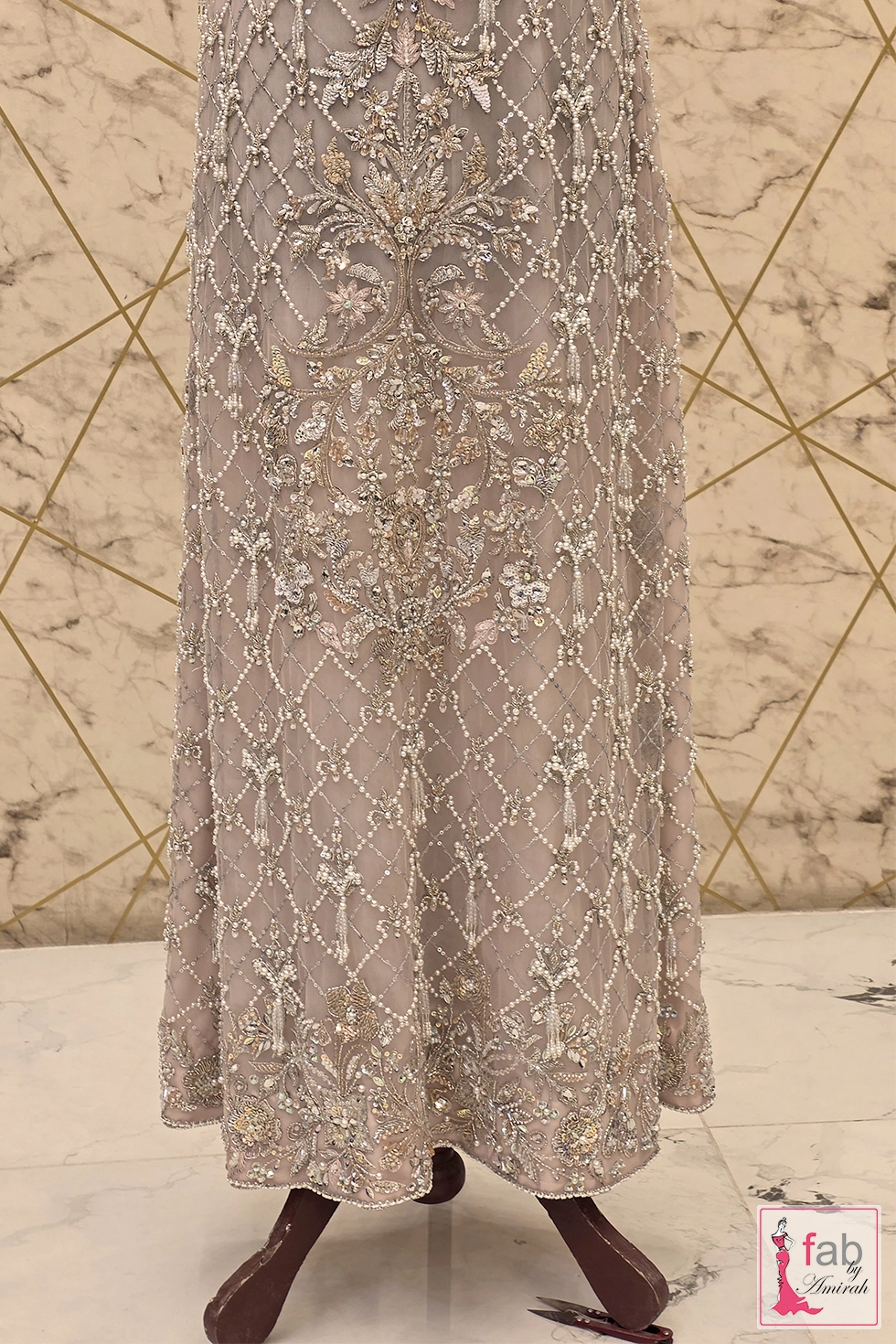 Skirt detail of embroidered net gown with pearl tassel trim