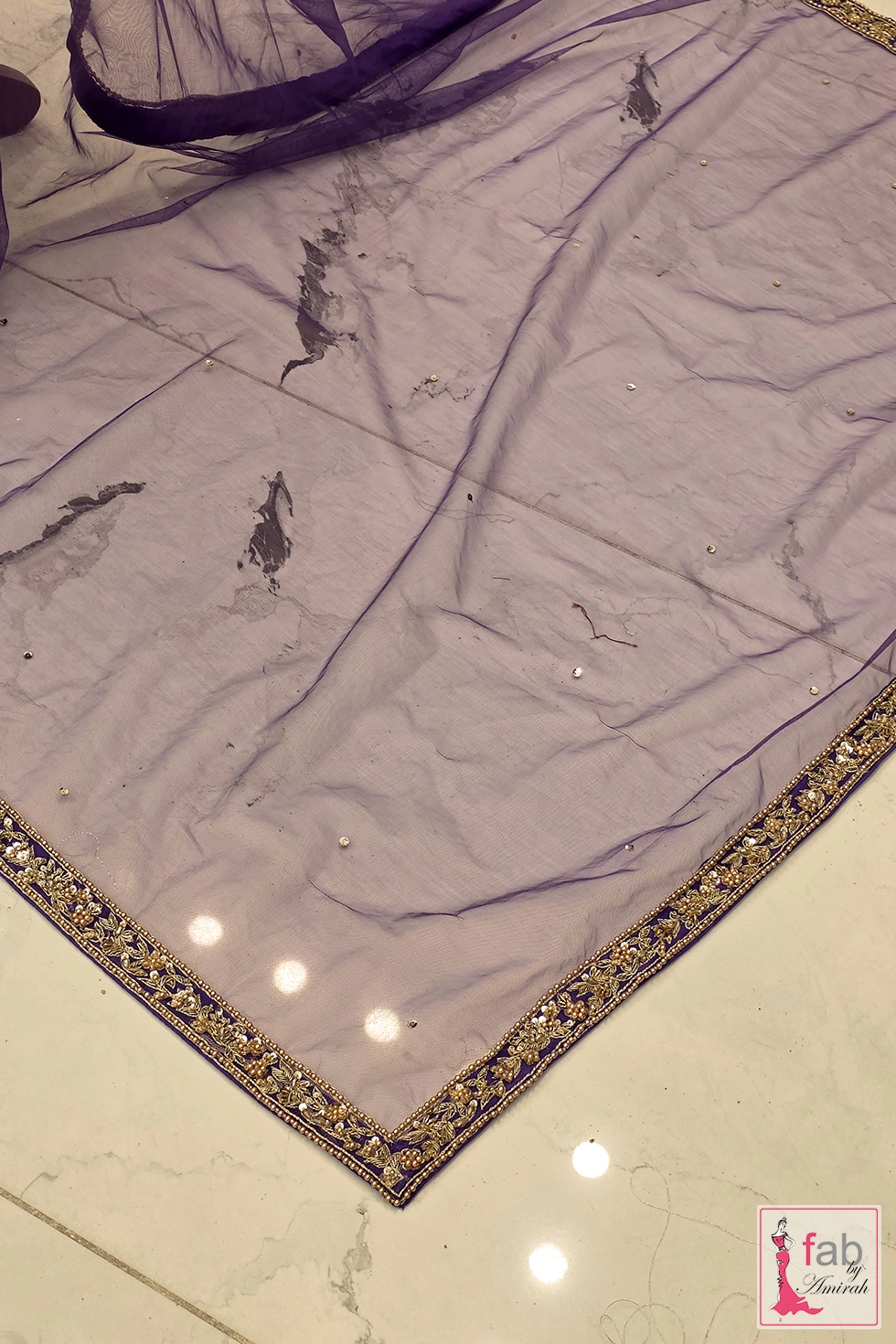Flat lay shot of purple net dupatta showing delicate gold zardozi borders Flat lay shot of purple net dupatta showing delicate gold zardozi borders