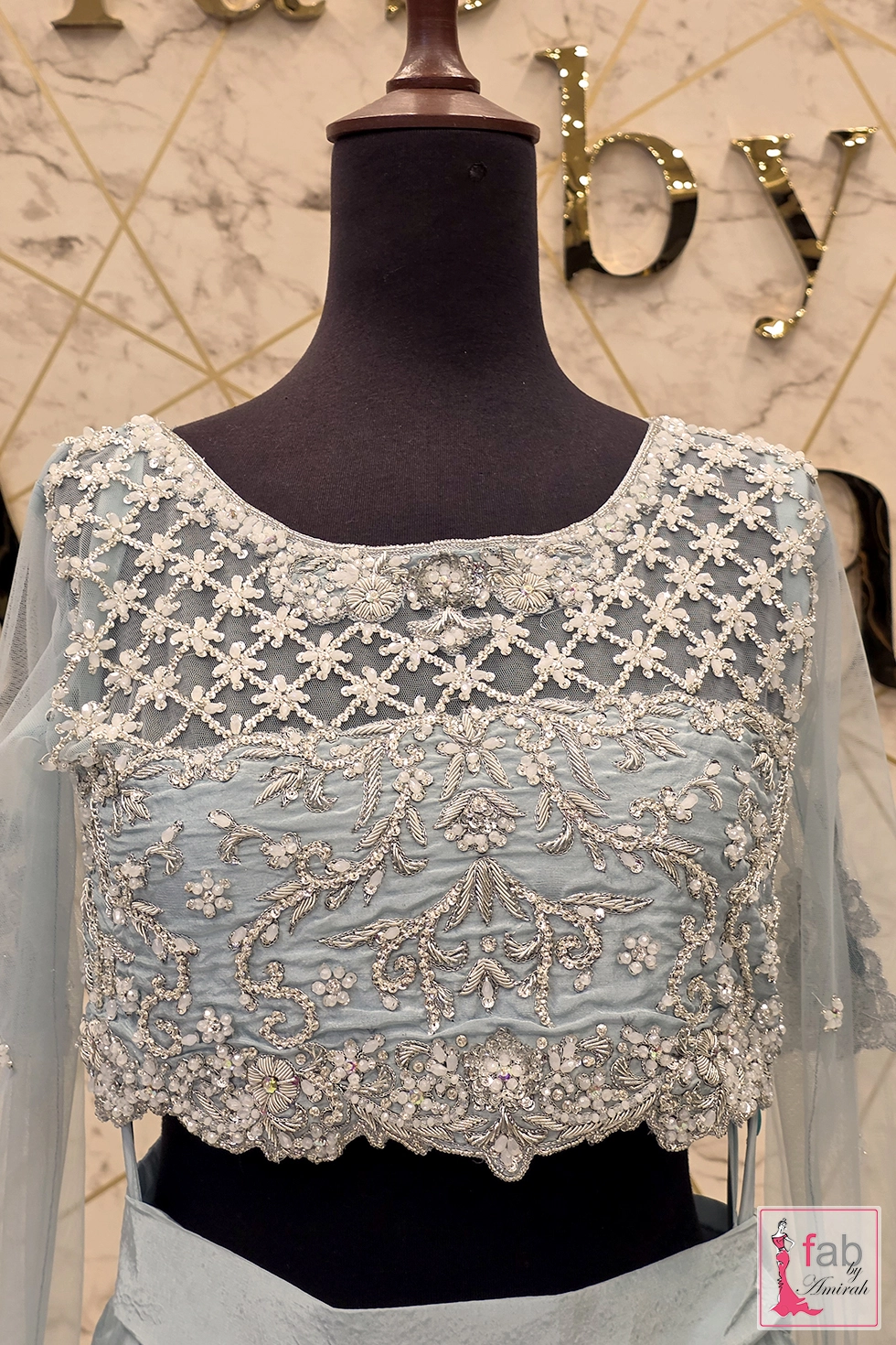 Front detailed close up of silver embellished choli bodice with sheer lattice mesh neckline