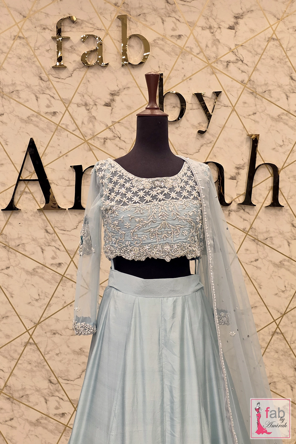 Upper torso shot of ice blue bridal blouse with long sheer sleeves and embellishment