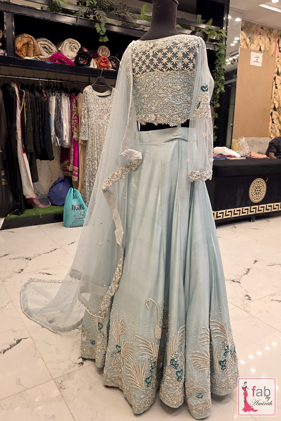 Back view of ice blue bridal lehenga and embroidered blouse on mannequin display