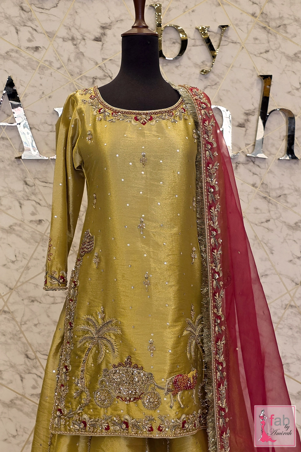Close up view of embroidered scoop neckline and royal carriage motif on shirt