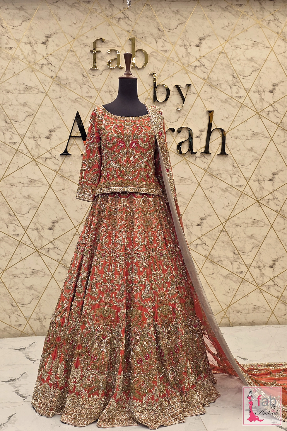 Rust bridal lehenga with hand embroidered gold zardozi on mannequin
