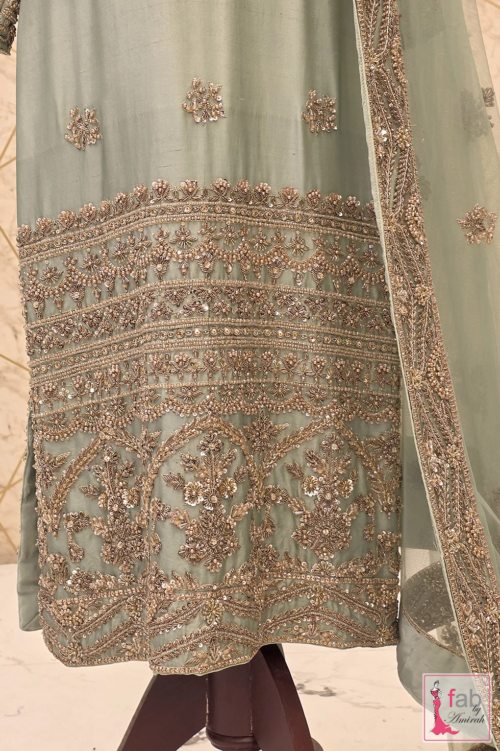 Close up of hemline embroidery on pistachio green formal wear suit