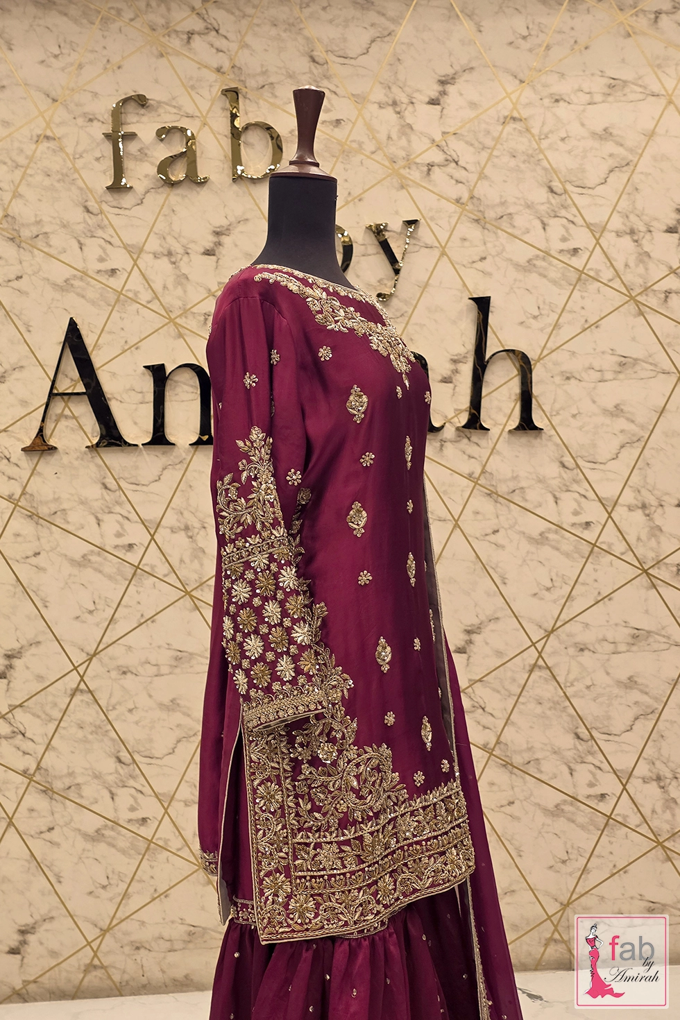 Side profile view of embroidered magenta suit on mannequin