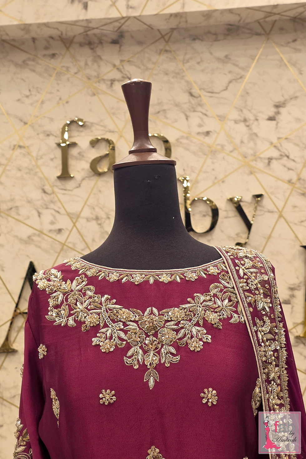 Close up of boat neckline featuring intricate floral gold zardozi